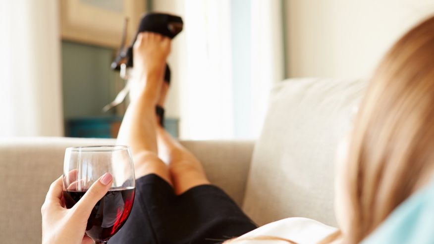 женщина пьет вино на диване