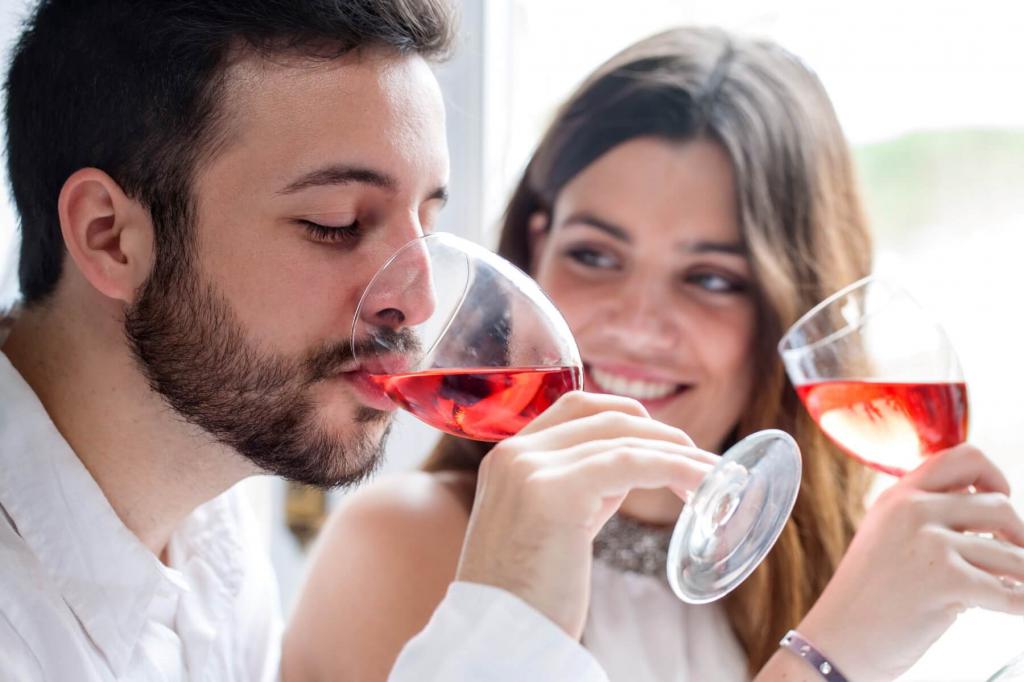 мужчина и женщина пьют вино из фужеров