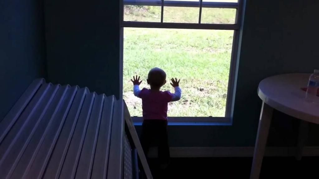Ребенок возле окна.