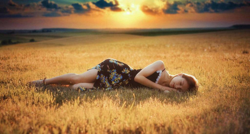 Девушка спит в поле.