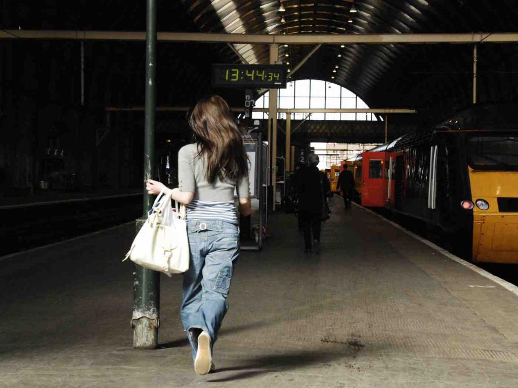 Девушка пытается догнать поезд.