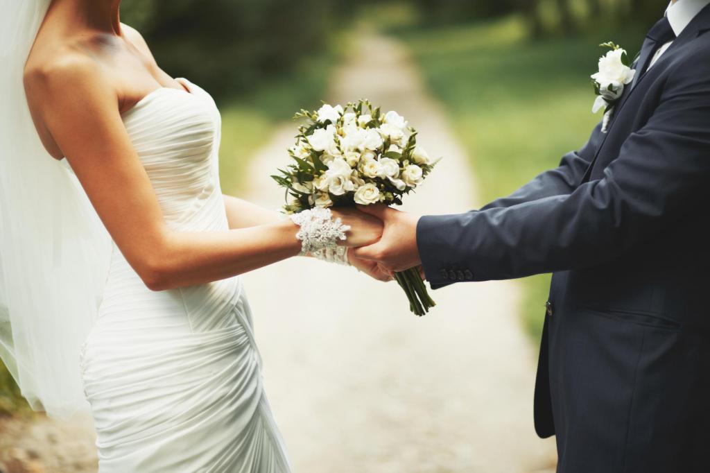Свадебный букет в руках жениха и невесты