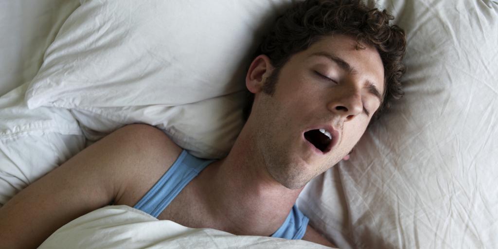 Мужчина спит с открытым ртом.