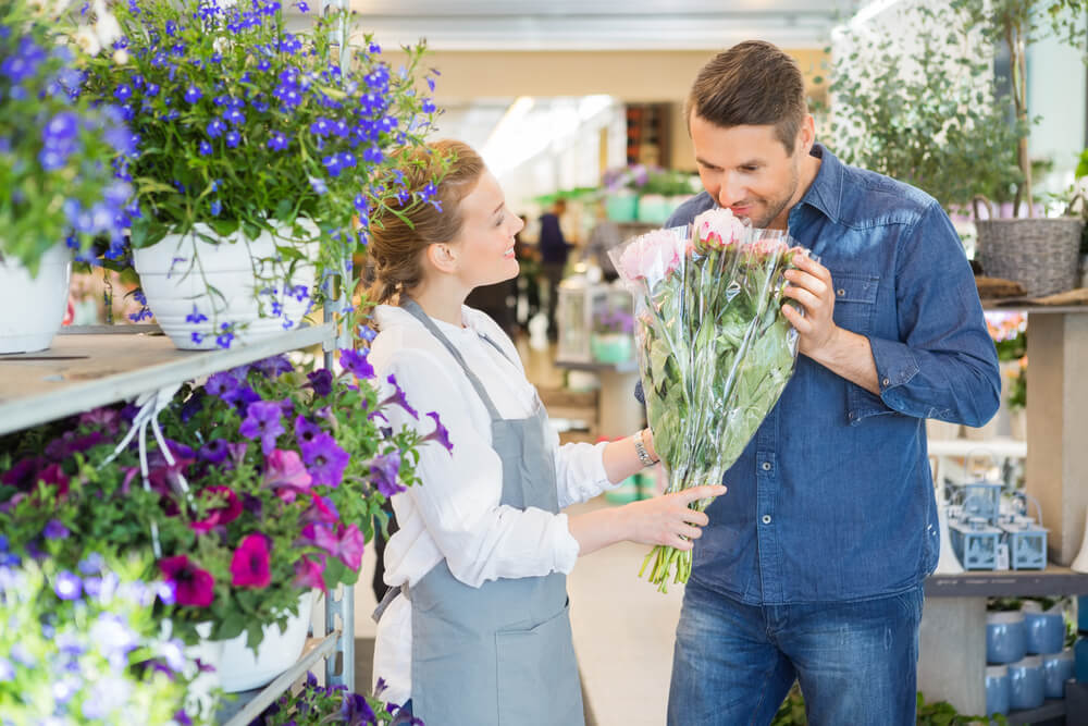 мужчина покупает цветы