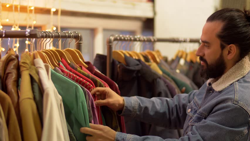 мужчина выбирает одежду в магазине