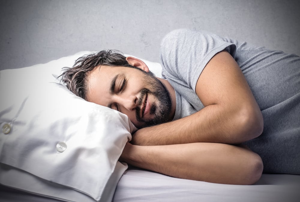 Бородатый мужчина спит в постели