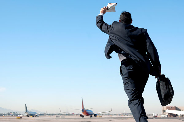 Мужчина в костюме бежит к самолету
