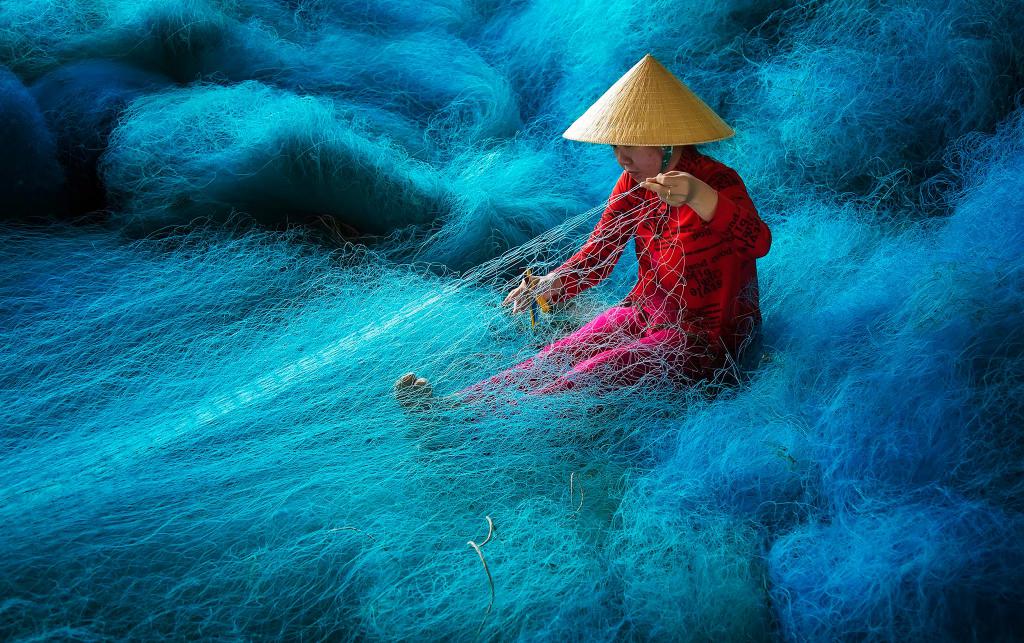 женщина ловит рыбу сетью