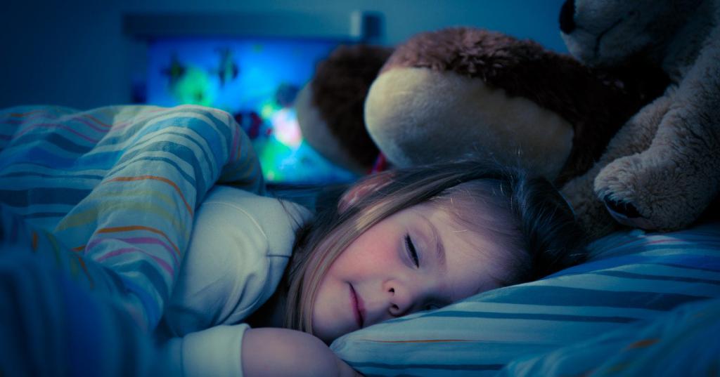 Маленькая девочка спит с плюшевым медведем