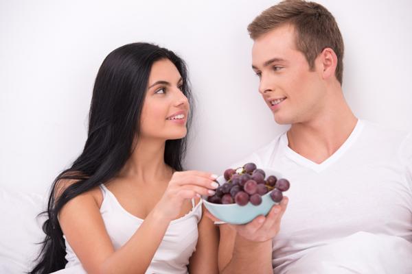 девушка и парень едят виноград