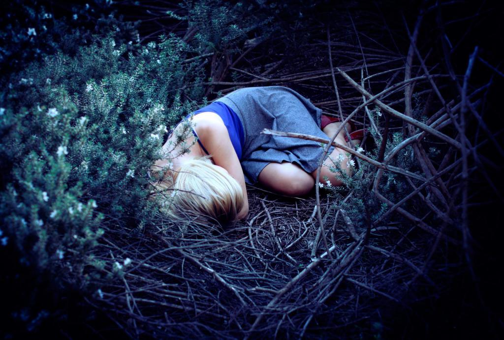 Девушка спит в лесу.