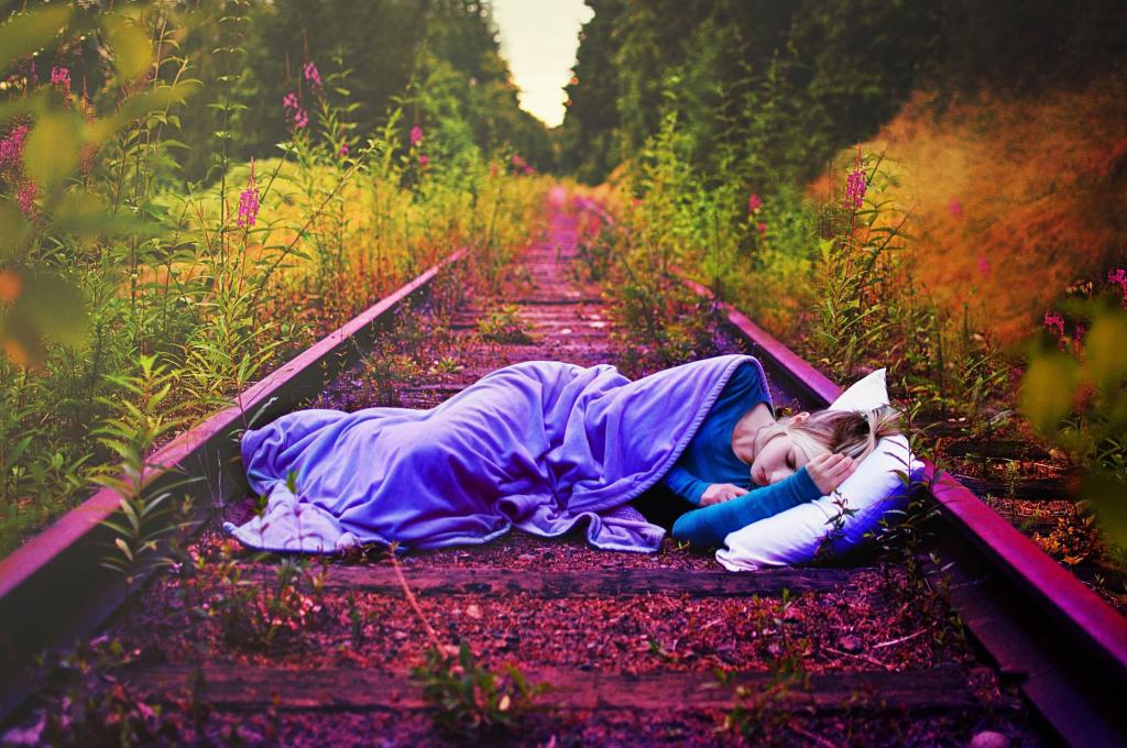 Девушка спит на железной дороге.