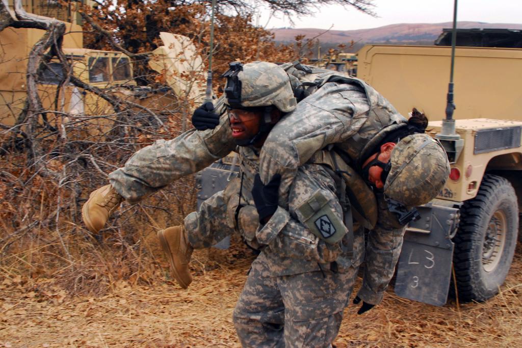 Американский солдат тащит раненого.